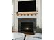 Close-up of fireplace, with a wooden mantel, a mounted TV and a grey tiled hearth at 425 Mccants Dr, Mount Pleasant, SC 29464