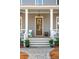 Inviting front entrance with a wooden door, bright sidelights, a porch with seating, and manicured landscaping at 425 Mccants Dr, Mount Pleasant, SC 29464