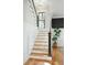 Elegant staircase with wood treads, black railing, and wainscoting detail at 425 Mccants Dr, Mount Pleasant, SC 29464