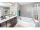 Bathroom features a soaking tub and shower next to double sinks with dark wood cabinets at 426 Mountain Laurel Cir, Goose Creek, SC 29445