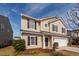 Two-story home with beige vinyl siding, black shutters, and an attached garage, set in a landscaped yard at 426 Mountain Laurel Cir, Goose Creek, SC 29445