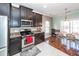 Modern kitchen with stainless steel appliances, dark cabinets and a view to the dining area with wood floors at 426 Mountain Laurel Cir, Goose Creek, SC 29445