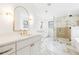 Bright bathroom with dual vanities, gold fixtures, marble floors, and a large glass-enclosed shower at 5 Maranda Holmes St, Charleston, SC 29403