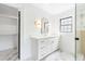 Clean, bright bathroom with white cabinets, arched mirror and marble-look flooring at 5 Maranda Holmes St, Charleston, SC 29403