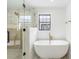 Bright bathroom featuring a glass-enclosed shower and soaking tub next to a window at 5 Maranda Holmes St, Charleston, SC 29403