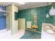 Retro bathroom featuring blue and light green tiling, floral wallpaper, and double sinks needing remodeling at 609 Levee Dr, Moncks Corner, SC 29461