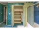 Bathroom with floral wallpaper, tiled shower, and a closet with white bi-fold doors and shelves at 609 Levee Dr, Moncks Corner, SC 29461