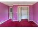 Bedroom with pink walls, red carpet, and closet, offering renovation potential at 609 Levee Dr, Moncks Corner, SC 29461