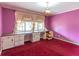 Bedroom with pink walls, red carpet, built-in desk, and natural light at 609 Levee Dr, Moncks Corner, SC 29461