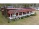 Rustic home featuring a covered porch with white pillars and red siding at 609 Levee Dr, Moncks Corner, SC 29461