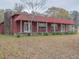 Charming home with a red metal roof, stone chimney, and a covered front porch at 609 Levee Dr, Moncks Corner, SC 29461