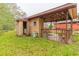 Exterior shot of a weathered shed and covered patio area with grass and leaf-strewn ground at 609 Levee Dr, Moncks Corner, SC 29461