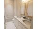 Bathroom with double vanity, two framed mirrors, and a white tiled tub and shower at 7626 Indigo Palms Way, Johns Island, SC 29455