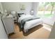 Bedroom featuring a large window, wood floors, and white and blue bedding at 7626 Indigo Palms Way, Johns Island, SC 29455