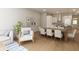 Open-concept dining room with hardwood floors and seating for eight adjacent to the living area at 7626 Indigo Palms Way, Johns Island, SC 29455