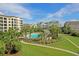 Beautiful community pool surrounded by lush landscaping, palm trees, and upscale resort-style buildings at 8000 Palmetto Dr # 506, Isle of Palms, SC 29451