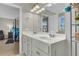 Bathroom vanity with double sinks, modern lighting, and an adjacent bedroom view at 9009 Cat Tail Pond Rd, Summerville, SC 29485