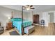 Bedroom featuring a four-poster bed, hardwood floors, a sitting chair, and dresser at 9009 Cat Tail Pond Rd, Summerville, SC 29485