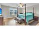 Bedroom with a four-poster bed, hardwood floors, a ceiling fan, and large windows for ample natural light at 9009 Cat Tail Pond Rd, Summerville, SC 29485