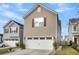 Home exterior features a spacious two car garage, beige siding, and trimmed lawn at 9009 Cat Tail Pond Rd, Summerville, SC 29485