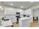 Bright kitchen features white cabinets, stainless steel appliances, an island, and hardwood floors at 9009 Cat Tail Pond Rd, Summerville, SC 29485