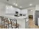 Open-concept kitchen with island bar seating, white cabinets, and stainless steel appliances at 9009 Cat Tail Pond Rd, Summerville, SC 29485