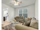 Bright living room featuring stylish sofas, a glass coffee table, and large window at 9009 Cat Tail Pond Rd, Summerville, SC 29485