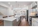 A bright kitchen showcases an island, white cabinets, stainless steel appliances, and an open layout to the living area at 1002 Carmela Ct, North Charleston, SC 29405