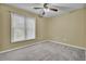 The bedroom is carpeted and painted in a neutral tone, has a large window, and a ceiling fan at 105 Peacock Pl, Summerville, SC 29485
