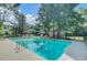 Clear community pool with marked depths and surrounded by lush greenery and seating at 105 Peacock Pl, Summerville, SC 29485