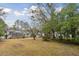 Extensive backyard with lush greenery and a charming house featuring a screened porch at 105 S Palmetto St, Summerville, SC 29483
