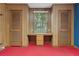 Bedroom featuring wood paneling, built-in desk with window, red carpet, and blue accent wall at 105 S Palmetto St, Summerville, SC 29483