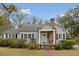 Charming single-story home with gray siding, brick chimney, manicured landscaping, and inviting front porch at 105 S Palmetto St, Summerville, SC 29483