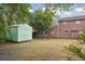Backyard view highlighting a shed alongside a brick building with a well-kept lawn at 105 S Palmetto St, Summerville, SC 29483