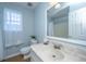 Well-lit bathroom featuring a marble countertop, sink, window and a decorative mirror at 1253 Lakefront Dr, Charleston, SC 29412