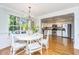 Bright dining area featuring a large window, hardwood floors, and a modern chandelier adjacent to the kitchen at 1253 Lakefront Dr, Charleston, SC 29412