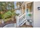 Inviting front porch with blue door, white railings, palm tree, and partial view of light beige exterior siding at 1253 Lakefront Dr, Charleston, SC 29412