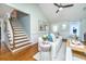 Bright living room featuring hardwood floors, a staircase, a white sofa with blue pillows, and modern decor at 1253 Lakefront Dr, Charleston, SC 29412