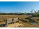 Scenic view from a bench overlooking the marsh and a wooden walkway, ideal for enjoying nature at 1253 Lakefront Dr, Charleston, SC 29412