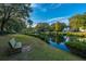 Tranquil pond view with a bench and waterside vegetation, backed by neighborhood homes and a bright sky at 1253 Lakefront Dr, Charleston, SC 29412