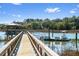 Scenic dock view with a gazebo, boat lift, and boat, leading to serene water views and coastal charm at 127 Oak St, McClellanville, SC 29458