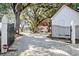 Charming home with a red roof, surrounded by mature trees and accessed through a secure gated entrance at 127 Oak St, McClellanville, SC 29458