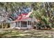 Charming home with screened porch, red roof, and lush landscaping at 127 Oak St, McClellanville, SC 29458