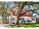 Charming home with a red roof, dormer windows, and mature trees at 127 Oak St, McClellanville, SC 29458