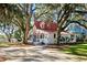 Beautiful home with mature trees, a red roof, and a welcoming front entrance at 127 Oak St, McClellanville, SC 29458