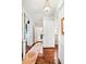 Charming hallway showcasing hardwood floors, chandeliers, and doorways to various rooms with unique decor and layout at 127 Oak St, McClellanville, SC 29458
