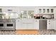 Stylish kitchen features stainless steel appliances, white cabinets, and modern tile floor at 127 Oak St, McClellanville, SC 29458