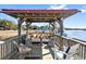 Inviting outdoor lounge on a wooden deck features comfortable seating and scenic waterfront views for relaxing and entertaining at 127 Oak St, McClellanville, SC 29458