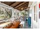 Relaxing screened porch with a wood dining table, overhead lighting, and exterior views at 127 Oak St, McClellanville, SC 29458