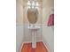 Charming powder room features a pedestal sink, oval mirror, and wainscoting at 128 Hornby Cir, Goose Creek, SC 29445
